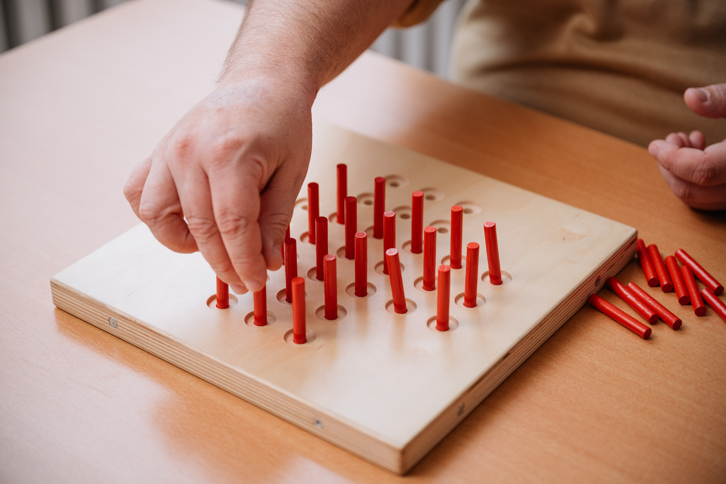Hirnleistungstraining - Nahaufnahme Steckbrett mit roten Steckern. Ergotherapeutische Praxis Engeldinger