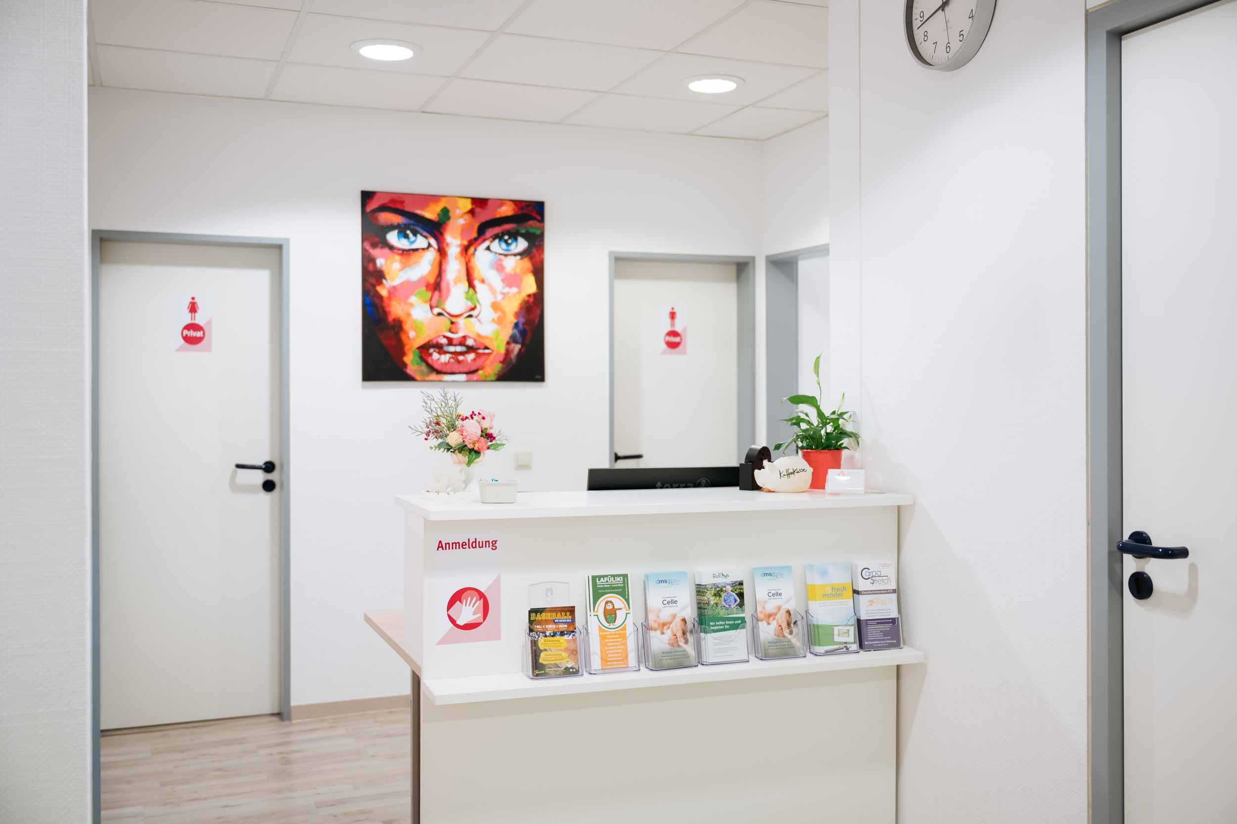 Wartebereich mit Empfangstresen der Ergotherapeutischen Praxis Engeldinger mit wei&szlig;en Sesseln.